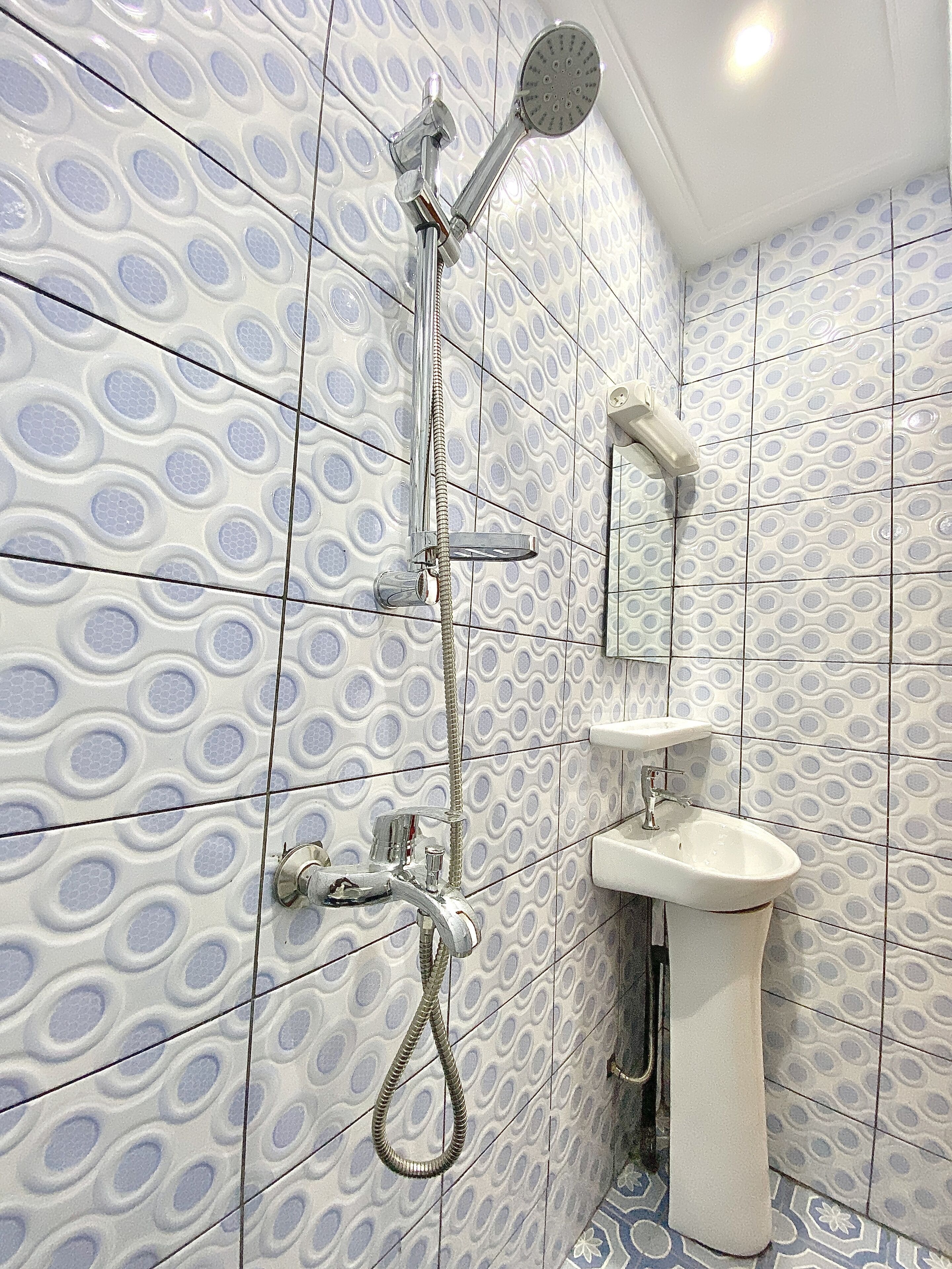 Un baño con ducha, lavamanos y espejo.