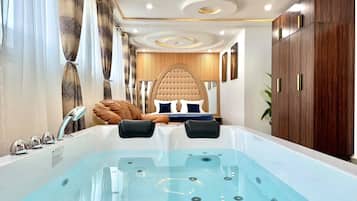 A modern bathroom with a large bathtub, a vanity with a mirror, and a shower area.