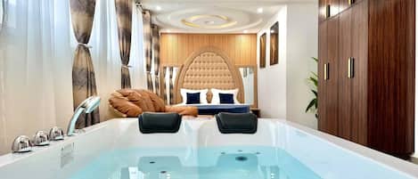 A modern bathroom with a large bathtub, a vanity with a mirror, and a shower area.