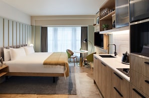 Studio | Ylelliset vuodevaatteet, tallelokero huoneessa, työpöytä