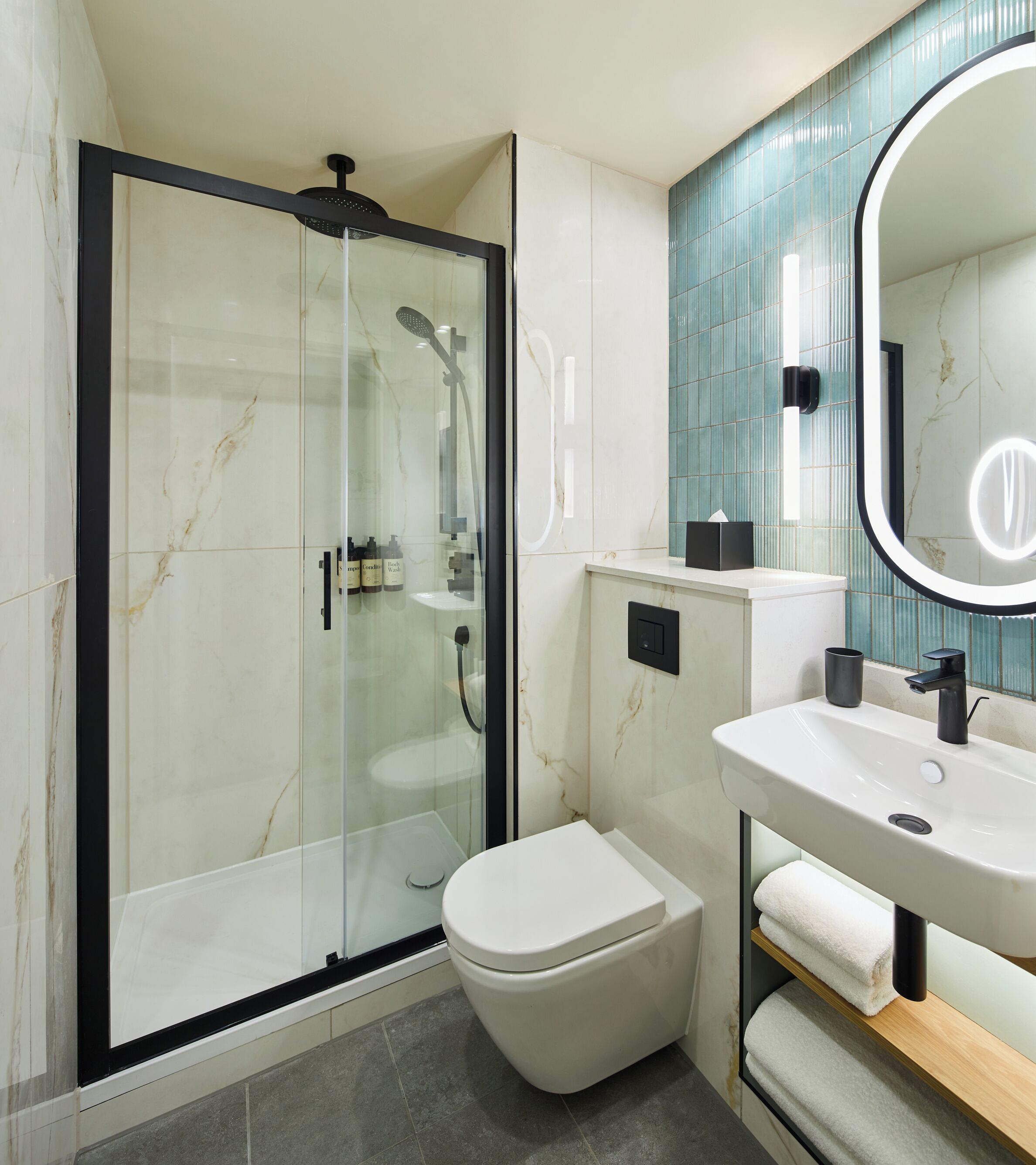 A modern bathroom with a glass-enclosed shower, a white toilet, a sink with a mirror, and a towel rack.