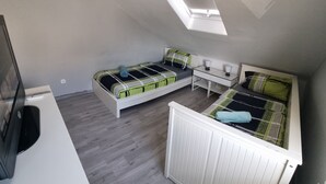 A compact room with two beds, a small table, and a TV. - Monteurzimmer Gelnhausen, Ferienwohnung, Auch für Große Gruppen, Nähe Frankfurt (Gelnhausen)
