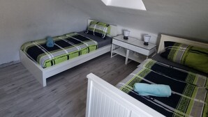 A compact room with two beds, a small table, and a skylight. - Monteurzimmer Gelnhausen, Ferienwohnung, Auch für Große Gruppen, Nähe Frankfurt (Gelnhausen)
