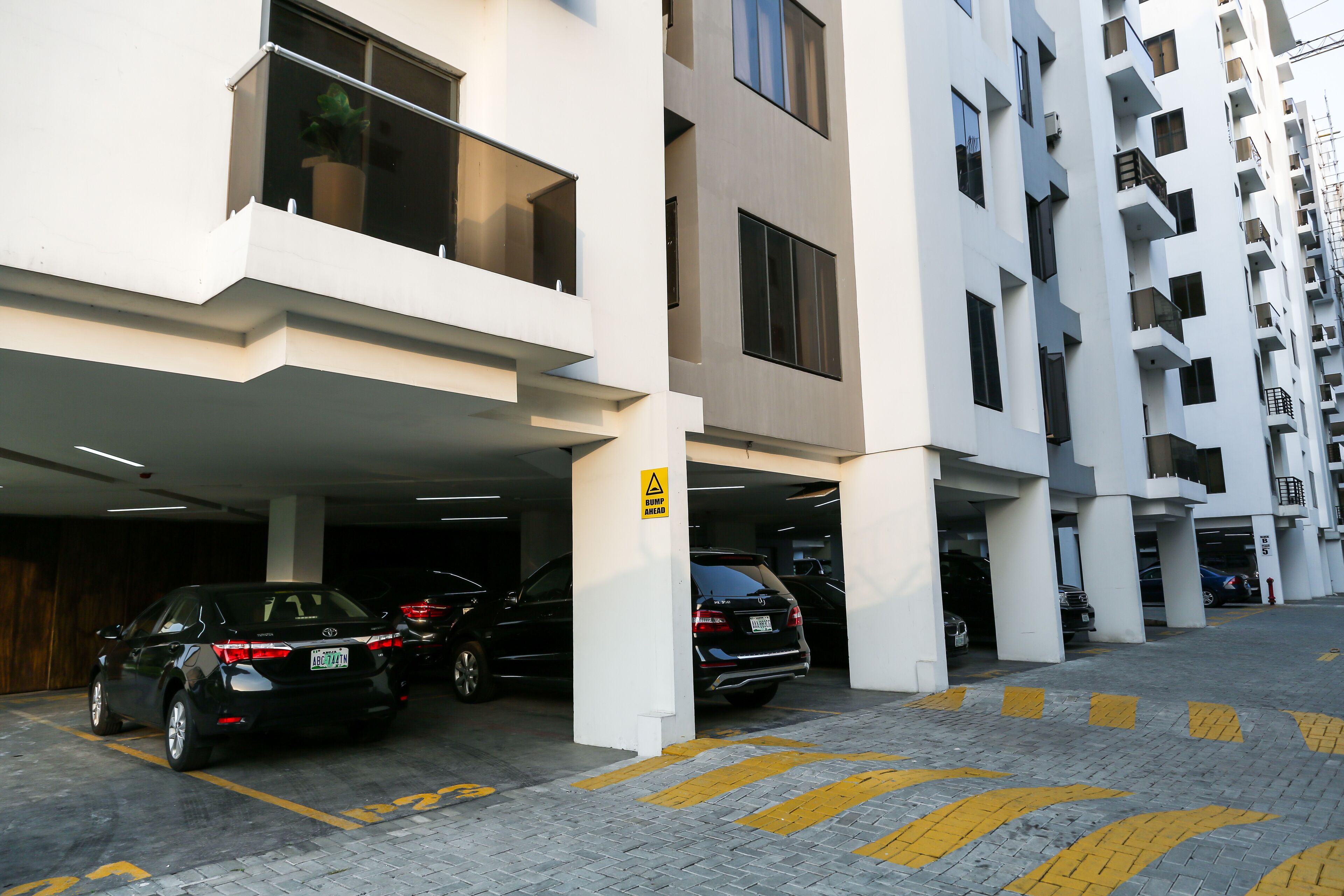 Un edificio residencial de varios pisos con estacionamiento.