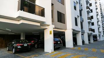 Un edificio residencial de varios pisos con estacionamiento.