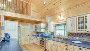 Una cocina amplia con armarios de madera, encimeras de granito y un ventanal grande.