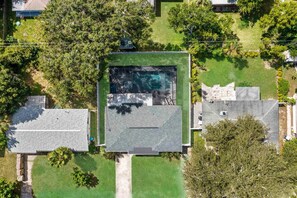 An aerial view of a residential area with a house featuring a large green lawn, a swimming pool, and a stone patio. - Private Heated Salt Water Pool Oasis • 10 Mins to Clearwater Beach (Clearwater)