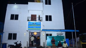 A two-story building with a sign for 'Aishwariyam Hotel' featuring 'Double, Triple Rooms & Dining Hall'. - Hotel Aishwariyam Thirukadaiyur (Tarangambadi)