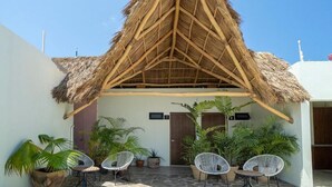 A thatched-roof structure with outdoor seating and potted plants. - Casa Pia Sayulita (Sayulita)
