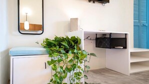 A modern bathroom with a white vanity, a mirror, a hanging light fixture, and a potted plant. - Casa Pia Sayulita (Sayulita)