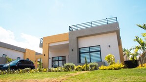 Um edifício moderno com telhado plano, janelas grandes e varanda.