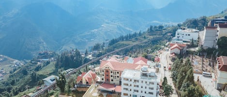 A mountainous village with terraced fields, a bridge, and residential buildings.