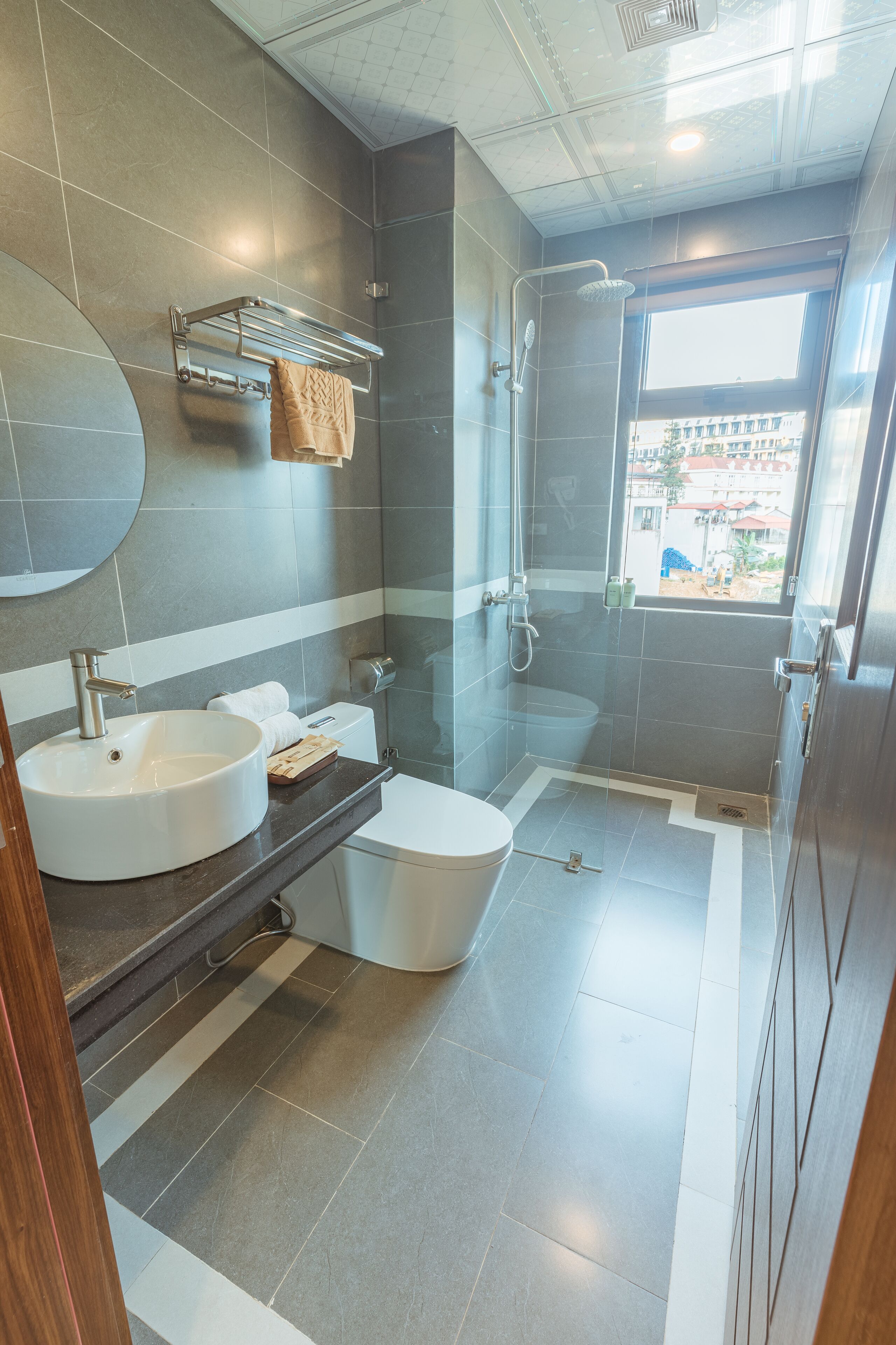 A modern bathroom with two sinks, a shower, and a toilet.