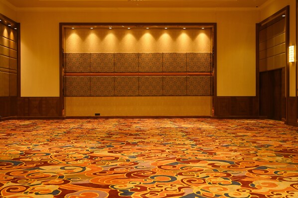 A carpeted hallway with a patterned floor and a wall with a panel design.