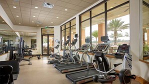 A gym with treadmills, exercise bikes, and weight machines. - Relaxing Regal Oaks Townhome (Kissimmee)