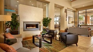 A spacious living area with a fireplace, comfortable seating, and a view of the outdoors. - Relaxing Regal Oaks Townhome (Kissimmee)