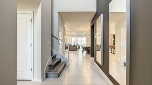 Un interior moderno con una escalera que conduce a una sala de estar, un comedor y una cocina.
