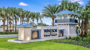 Señal del Resort Windsor Island, con un muro de piedra, techo azul y palmeras.