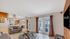 A modern living room with a sofa, coffee table, and a flat-screen TV.