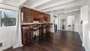 Una cocina moderna con armarios de madera, una barra con taburetes y vistas al exterior.