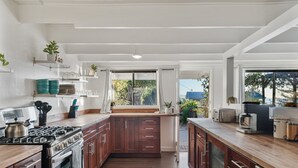 Una cocina moderna con armarios de madera, horno empotrado y un amplio ventanal.