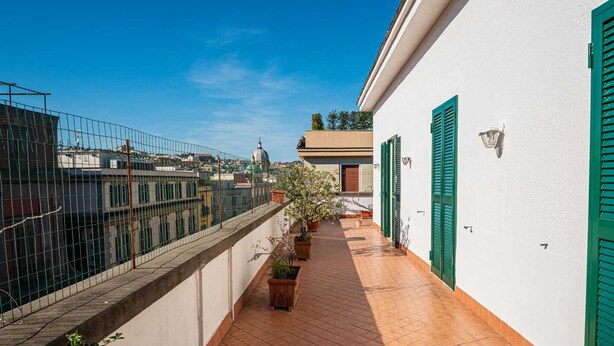 A narrow corridor with tiled flooring, green shutters, and potted plants. - Casa Toledo: Spazioso Attico in Centro , a 20 Metri Dalla Stazione Metro Toledo (Napoli)