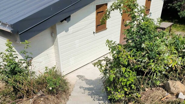 Una escalera de hormigón que lleva a un edificio blanco de techo oscuro.