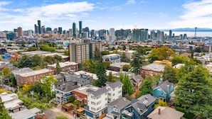 A cityscape with a mix of residential and commercial buildings, including a prominent tower and the Space Needle. - Caraxes's Blood Wyrm Lair (Seattle)
