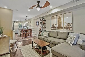 Relax in this inviting living room with a sofa, dining area, and kitchen view.