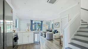 A modern kitchen with white cabinetry, a built-in oven, and a dishwasher.