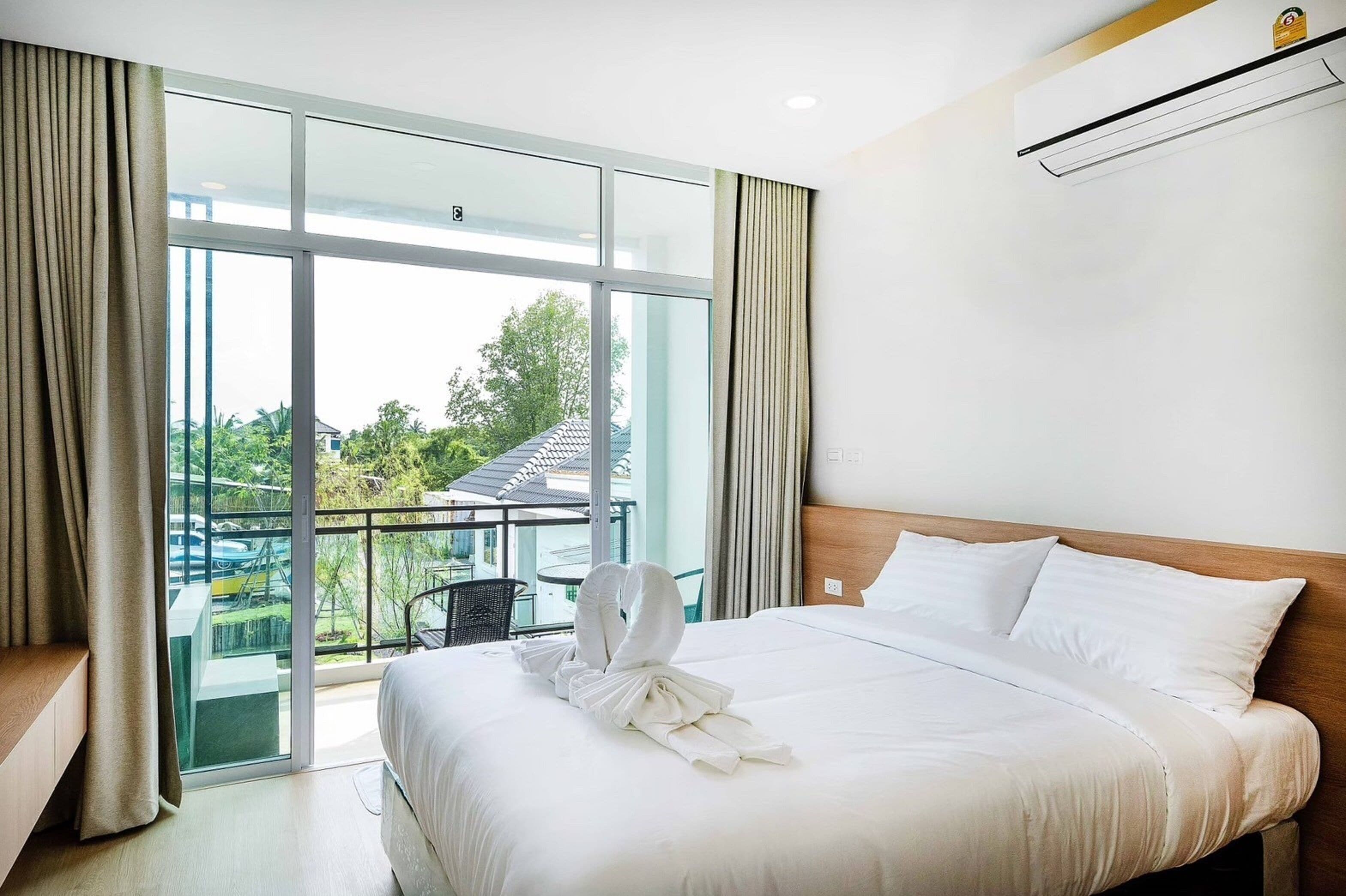 Habitación de hotel con una cama grande, vistas a un balcón y un diseño moderno.