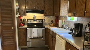 A kitchen with wooden cabinets, stainless steel appliances, and a tiled backsplash. - Southern Charm and Convenience: Perfect VRBO Retreat Near Ole Miss and Tupelo. (Pontotoc)