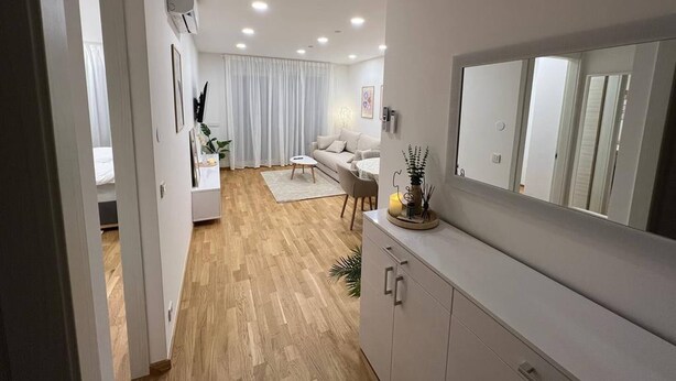 Un saló modern amb un sofà, una taula de centre i un mirall gran.