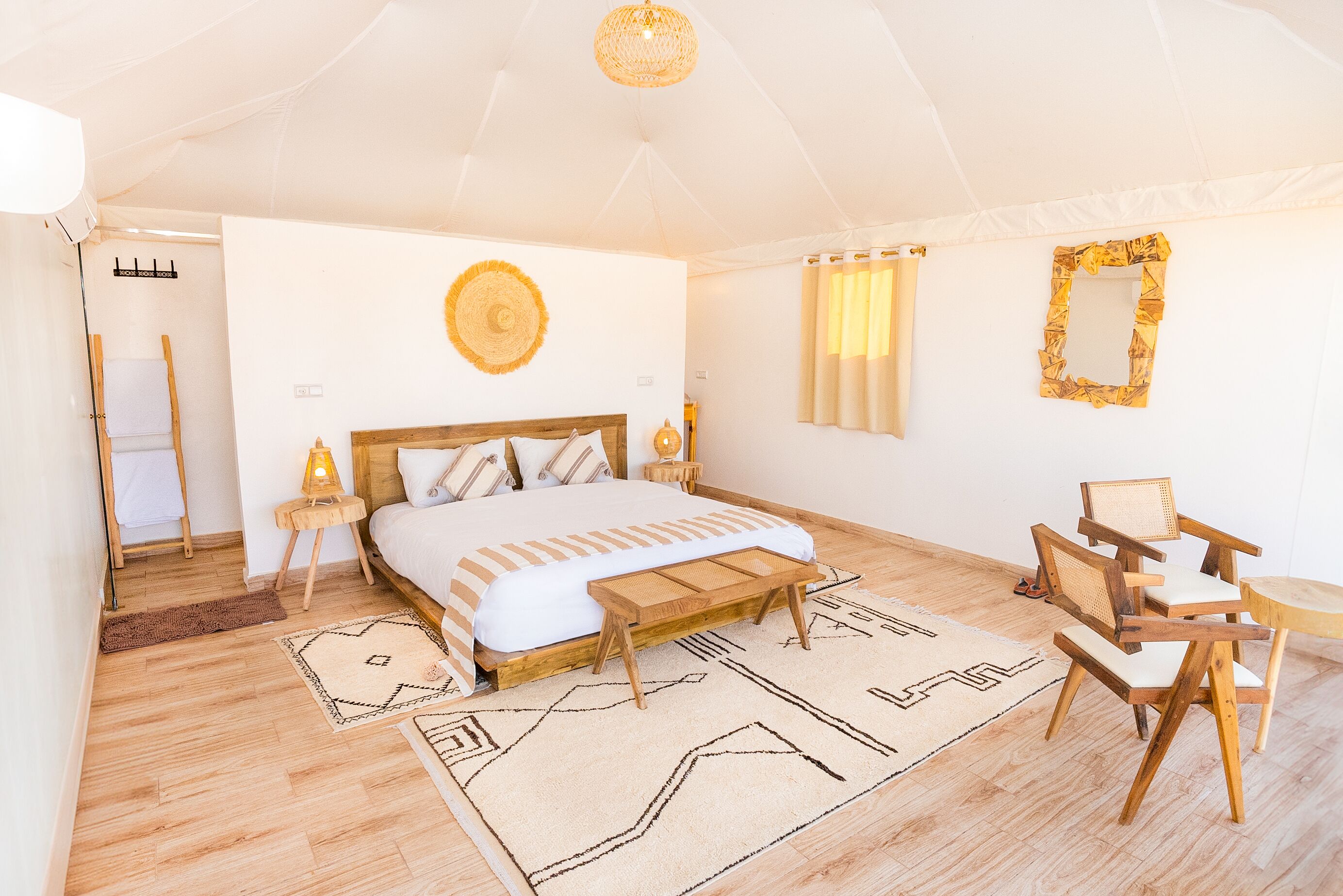 Une chambre spacieuse avec un grand lit, des meubles en bois et un ventilateur de plafond.