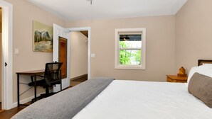 A bedroom with a bed, a desk, and a window. - Walk to Beach - Pet friendly Cabin w/ Workspace (Lake George)