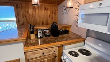 Una cocina con armarios de madera, una estufa blanca y lámparas colgantes.