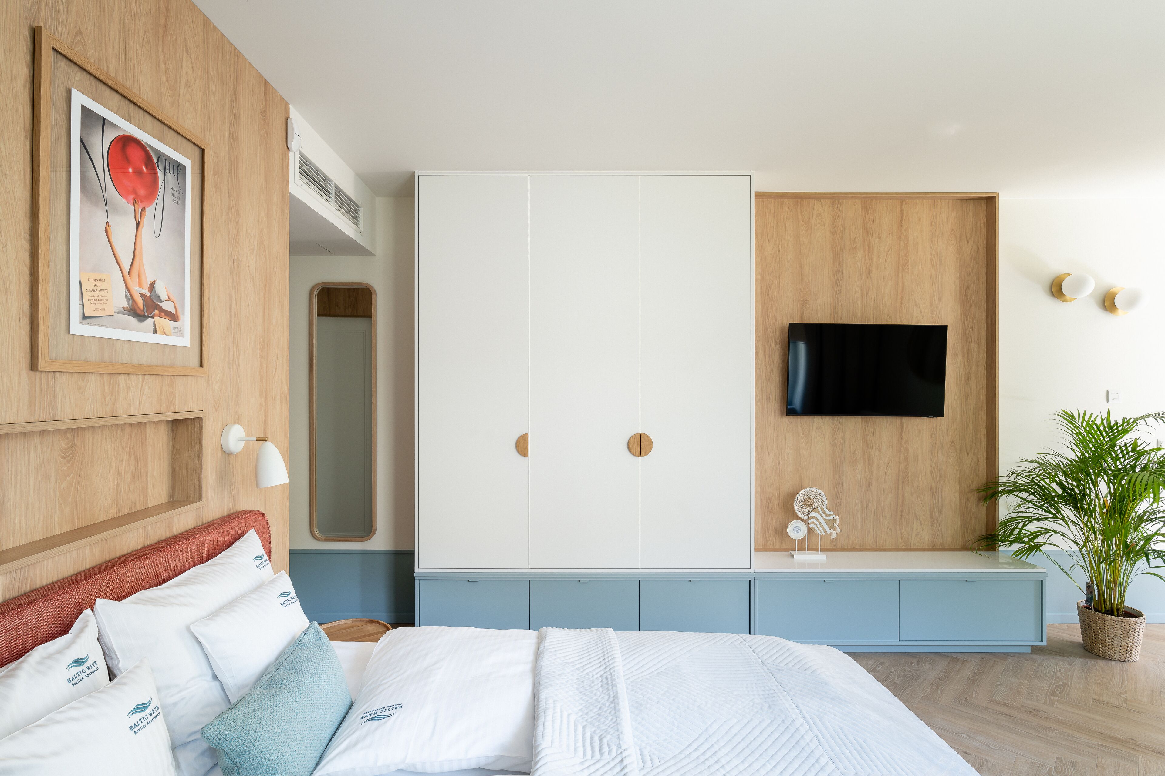 Une chambre à coucher moderne avec un lit, une armoire, un téléviseur et une plante.