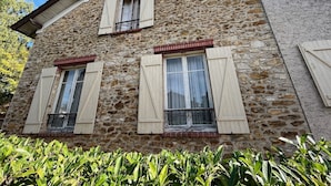 A stone building with three windows, each with shutters, and a balcony. - Grande Maison Traditionnelle Proche de la Forêt (Brunoy)