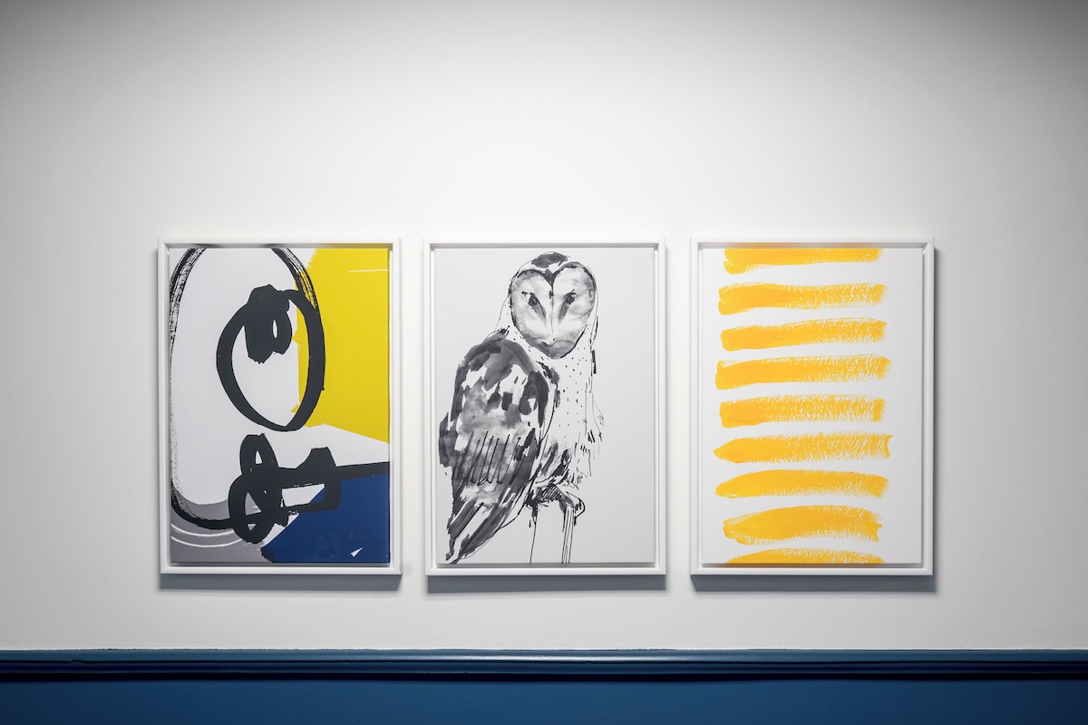 Three framed artworks on a wall.