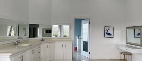 Een moderne badkamer met een grote spiegel, twee wastafels en een badkamermeubel.
