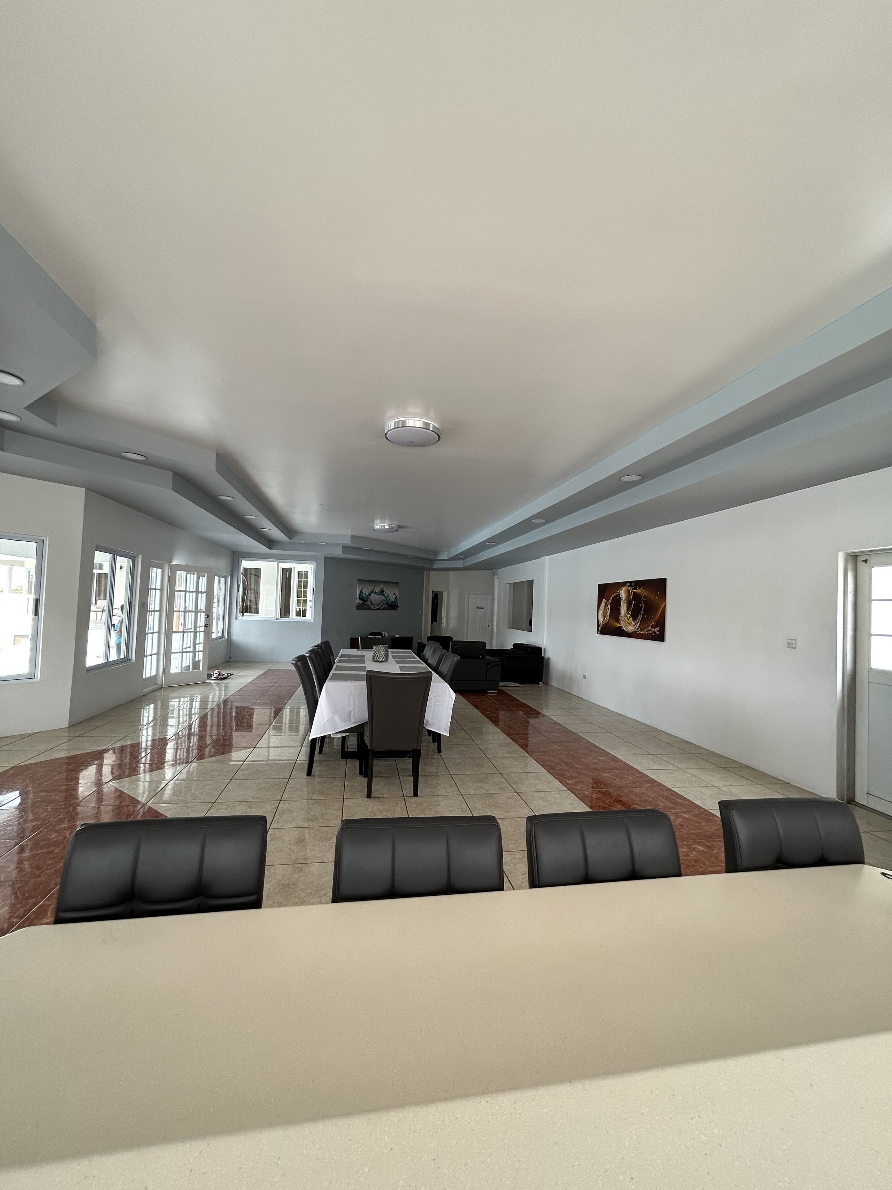 A spacious conference room with a long table, several chairs, and a large window.