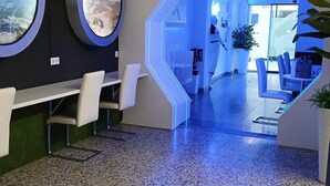 Una zona de recepción moderna con un diseño hexagonal único, un mostrador de recepción, un área de estar y vistas al exterior.