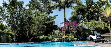 Una piscina al aire libre, tumbonas