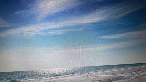 Een strand met heldere lucht en een rustige zee.