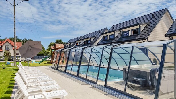A covered swimming pool with lounge chairs and a greenhouse structure. - Pet friendly home in Jantar with sauna (Jantar)