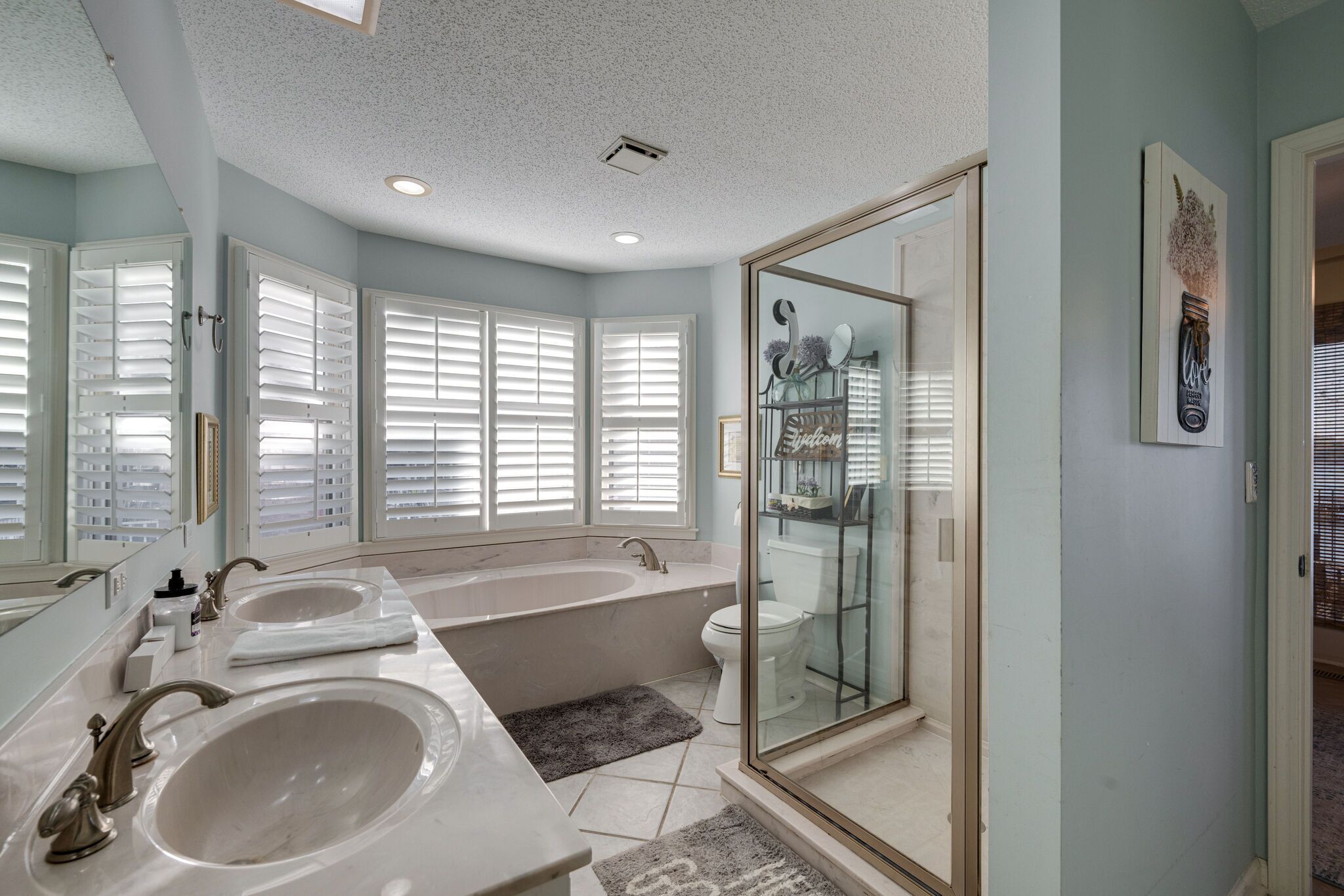 Une salle de bain moderne avec deux lavabos, une baignoire et une douche à l’italienne.