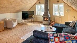 Una sala de estar acogedora con chimenea, televisor, sofá y una mesa de centro.