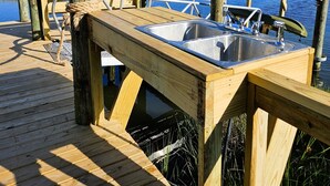 A wooden dock with a metal sink and railing, overlooking a marshy water body. - A Turtle's View-Waterfront-Dock-Fenced Yard-Dog Friendly (Surf City)