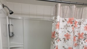 Ein Badezimmer mit Badewanne, Dusche und einem blumigen Duschvorhang.