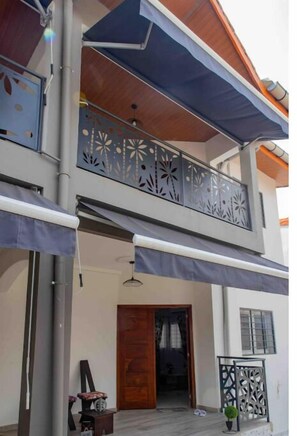 Enjoy the view from the upper floor balcony with a decorative railing and access to a cozy entrance.